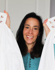 Woman holds up two white sheets attached at four points to their Wad-Frees
