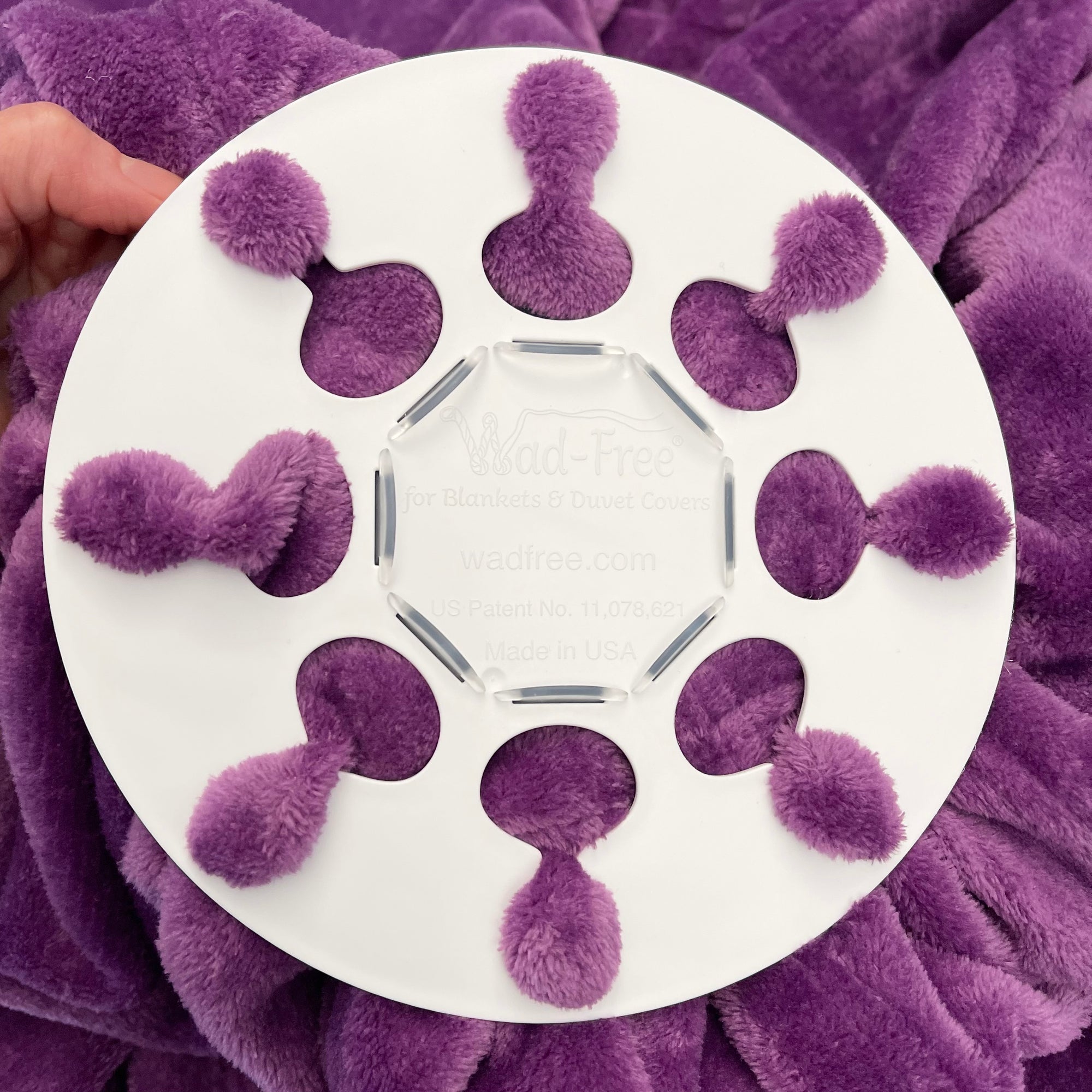Wad-Free for Blankets & Duvet Covers White round Wad-Free attached to plush purple blanket using 8 tabs