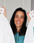 Wad-Free Inventor Cyndi Bray in a teal sweater shows two white sheets attached to their Wad-Frees
